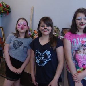 Trzy dziewczynki z pomalowanymi twarzami.